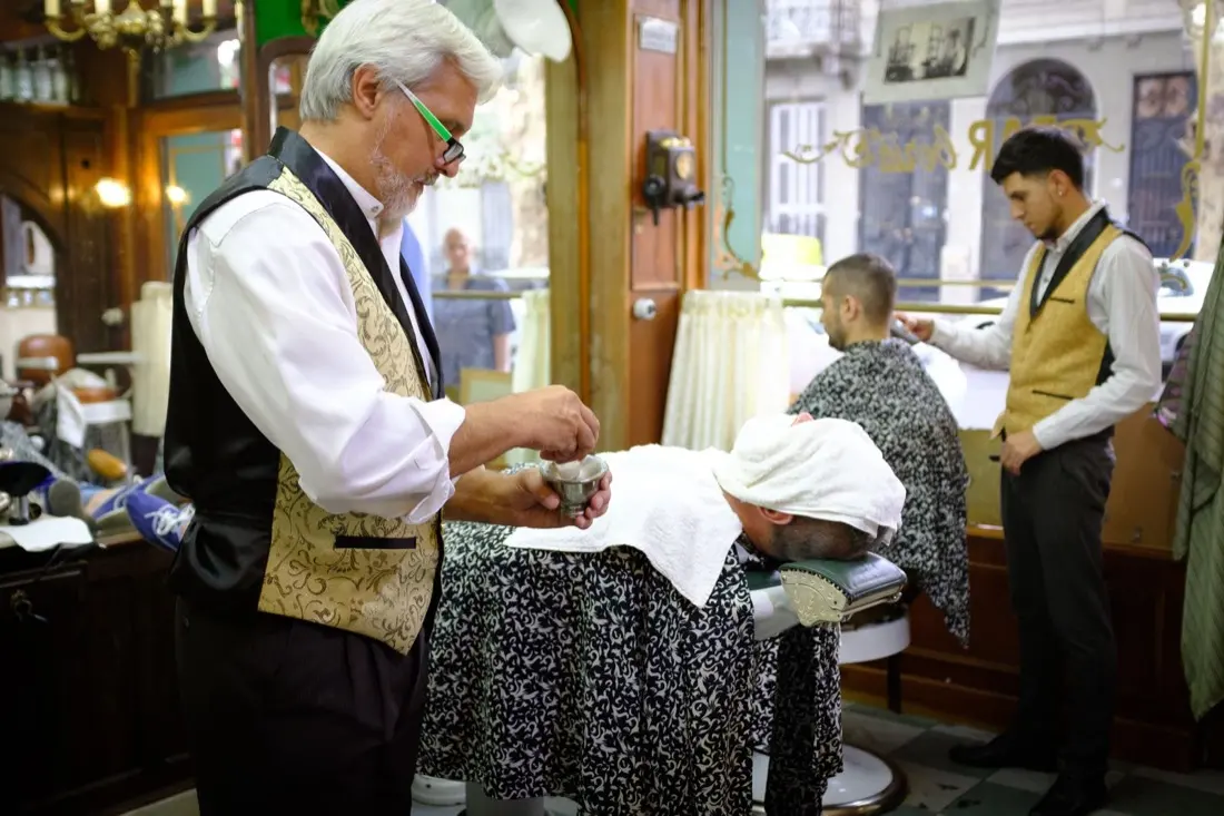 A classic barbershop floor: vested barbers working their chairs