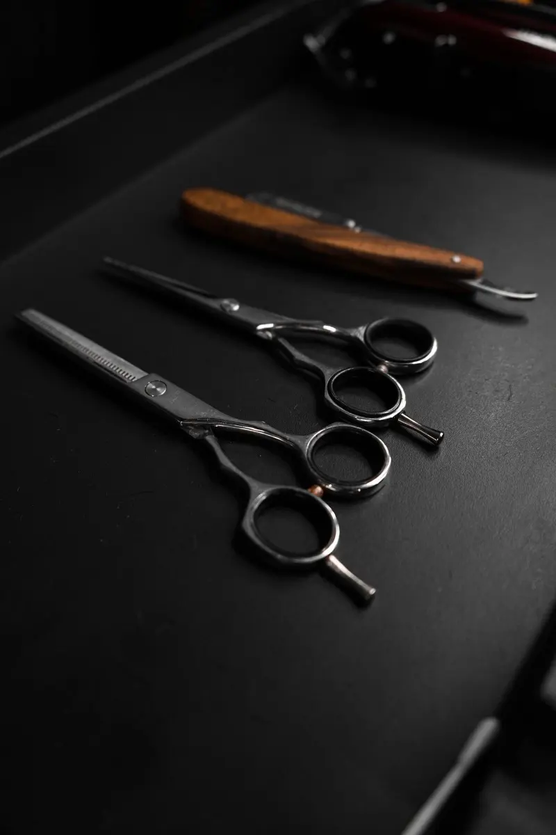 Straight razor and shears on a dark station